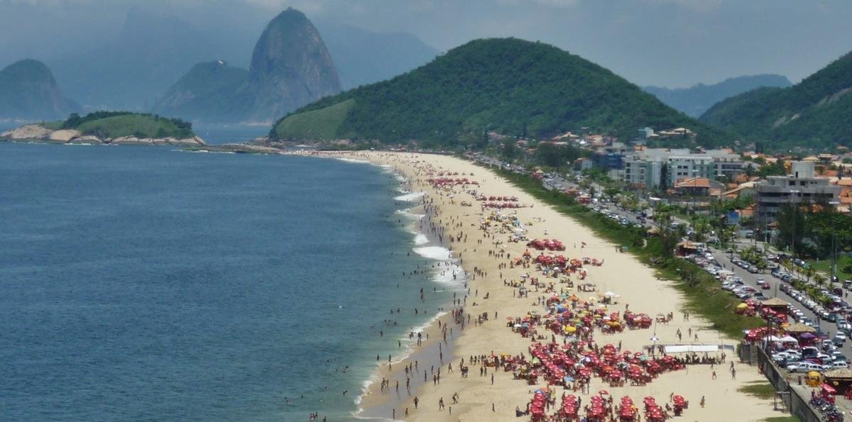Praia amada em Niterói tem águas calmas e vista para o Cristo Redentor